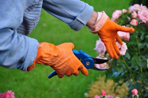 Landscapers handling machinery with safety controls in place